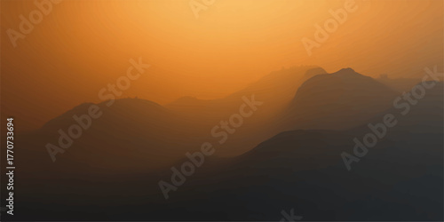 Dramatic mountain peaks shrouded in mist and fog illuminated by a warm golden sunset sky