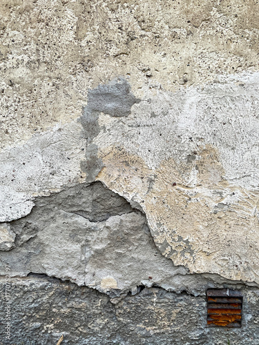 Old broken wall with vintage rusty vent.