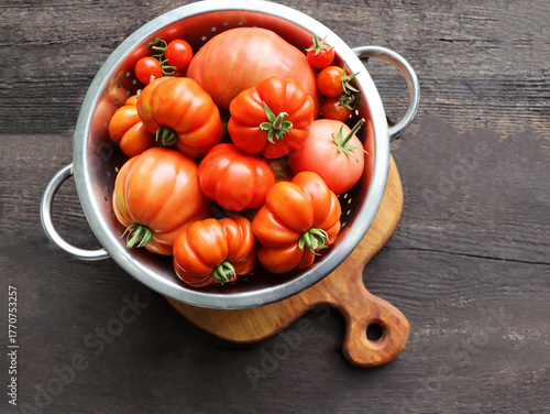 Fotografie Tomatoes in a Stainless Steel Colander For Washing on Wooden Table Top View