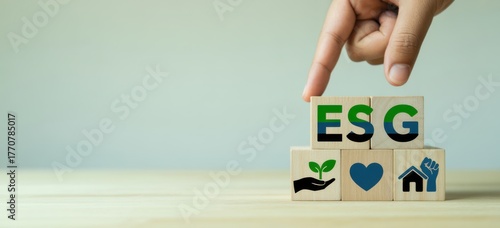 ESG Concept Illustration: A hand carefully positions wooden blocks spelling ESG, a visual representation of environmental, social, and governance principles, with corresponding icons.