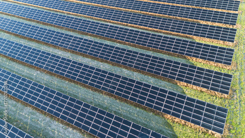 Aerial view of large sustainable electrical power plant with rows of solar photovoltaic panels for producing clean electric energy. Concept of renewable electricity with zero emission