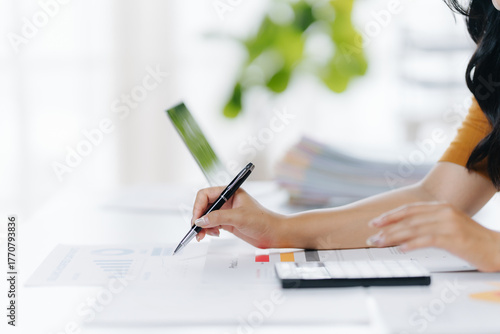 Fotografi Working Detail: A focused professional meticulously reviews and signs financial documents, emphasizing precision and attention to detail