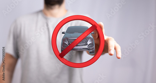 Bild auf Leinwand Image of a man holding a red circle with a car inside, symbolizing a no car zone or restriction