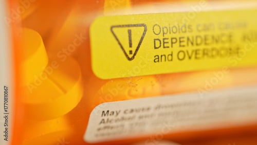 Prescription bottle with warning stickers saying, Opioids can cause dependence, addiction and overdose. Opioids effective for managing chronic pain, but also come with potential risks and side effects