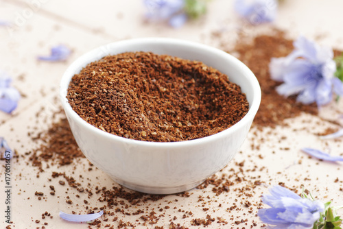 Ground chicory root powder in a bowl, healthy coffee substitude drink, closeup, natural medicine and naturopathy concept