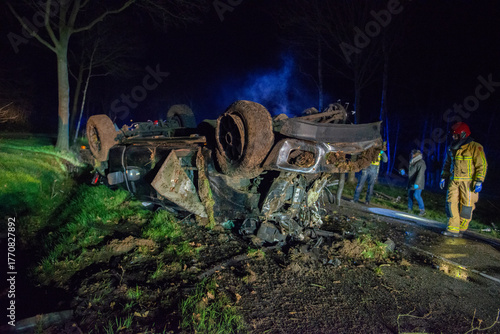 Firefighters are working to right a pickup truck that has overturned