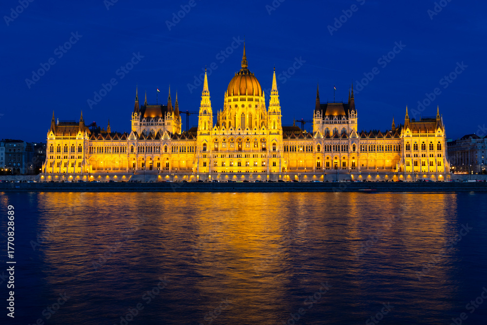 Fototapeta premium The Danube river and 1902 Gothic Revival style Parliament illuminated seen from Buda during the evening blue hour, Budapest, Hungary
