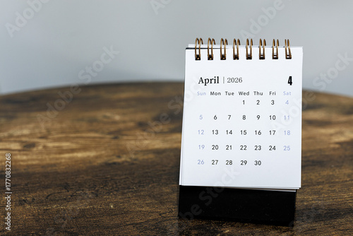 April 2026 calendar monthly page on wooden table background