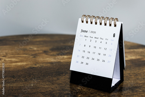 June 2026 monthly calendar page on a wooden desk, minimal design planner representing time management and organization at workplace