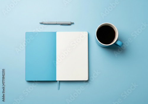 Minimalist Black Workspace Flat Lay of Open Notebook, Pen, and Coffee Cup on a Light Blue Surface. Perfect for Journaling and Planning