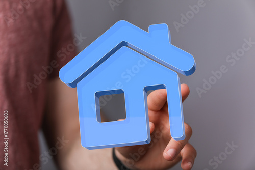 A hand holding a blue house...