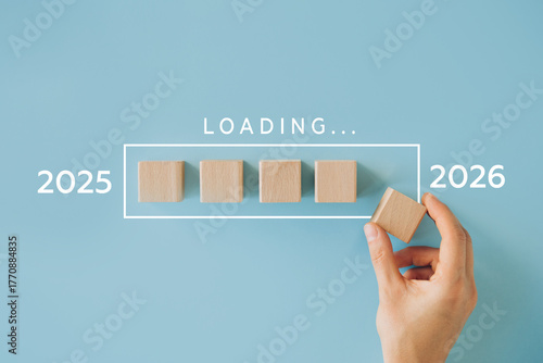 Transition from 2025 to 2026 loading concept with wooden cubes. Represents time passing, preparation for the new year, planning, and progress