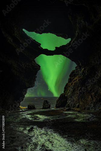Foto Yoda Cave at Hjoerleifshoerfdi in Iceland with aurora borealis at the background
