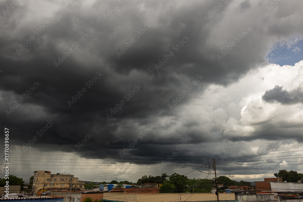 Fototapeta premium Dark storm clouds before a thunder-storm in the town