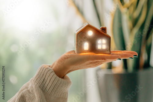 Wallpaper Mural hand holding a house with light and lighting, energy Torontodigital.ca