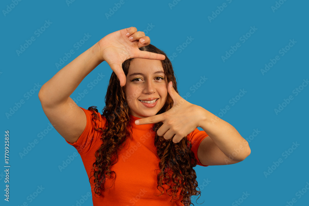 Fototapeta premium Young woman framing face with hands creating vision