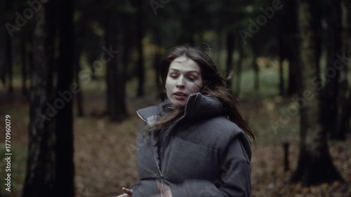 Terrified woman running through dark forest escaping danger