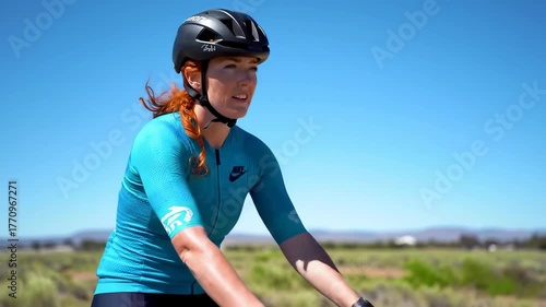 Woman in cycling gear puts on helmet under a clear blue sky.