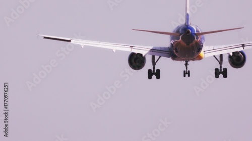 airplane flying overhead to land at airport in slow motion