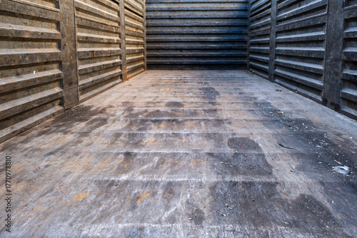 Worn empty truck bed with rust and scratches. Weathered empty truck body with rusty metal texture. Old industrial truck cargo box showing signs of wear.