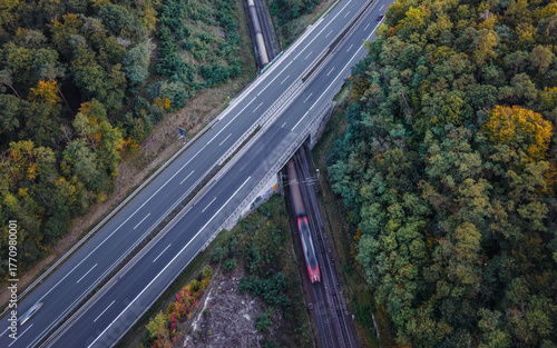 Aerial view of the freight train passing under the highway