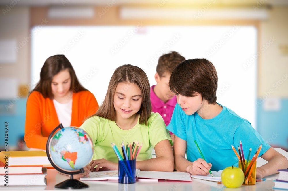 Fototapeta premium Happy small kids at school learning in class.