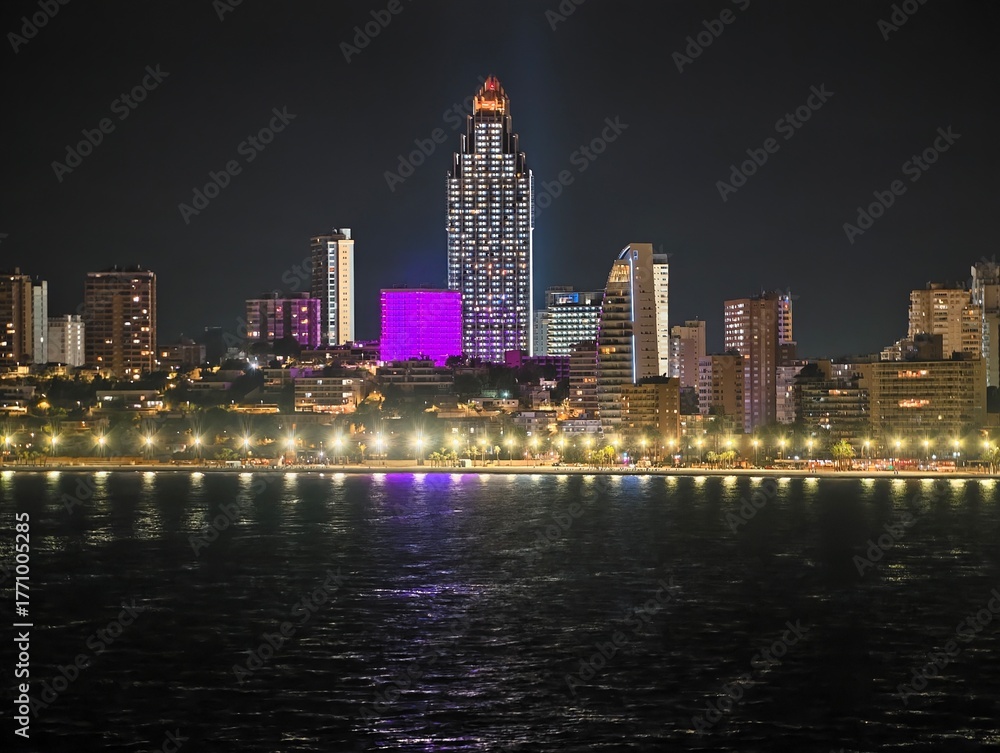 Fototapeta premium evening skyline highlights, night scene featuring illuminated structures and seaside reflections