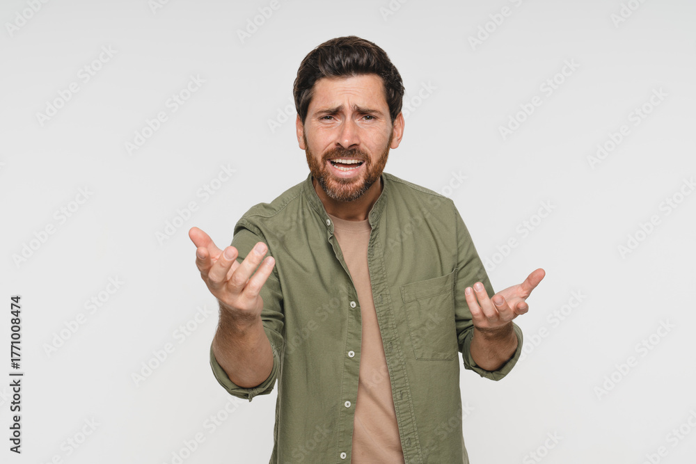 Fototapeta premium Head shot portrait dissatisfied man in casual frowning eyebrows having dissatisfied grumpy face expression posing over white studio background negative emotions irritated person concept image
