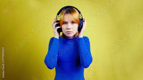 Young woman listening to music on headphones and dancing