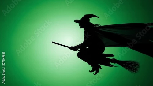 Silhouette of Witch Flying on Broom Across Green Sky