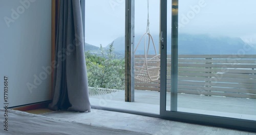 Sliding door opening slowly, curtain swaying, sparkles drifting downward revealing mountain view