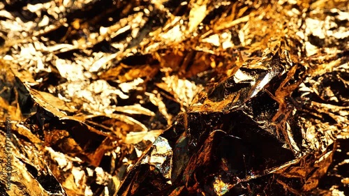 Gold foil wallpaper. Shiny gradient shimmer foil background.Textured beautiful background in golden tones. 4k footage