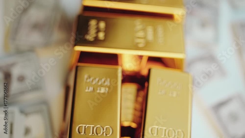 Shiny pure gold bars stacked in a pile resting on a bed of us dollar banknotes, representing wealth, banking, investment, and financial security in the global economy and market