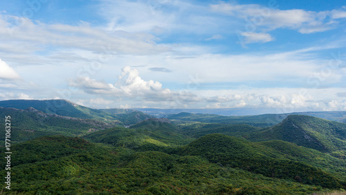 Photos Panoramic view of rolling green hills and forest landscape under a bright sky near Tbilisi, Georgia