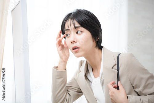 A woman in a suit checking her appearance before heading to work A busy morning with no time to spare