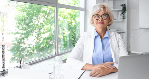 Female doctor sitting at table in clinic