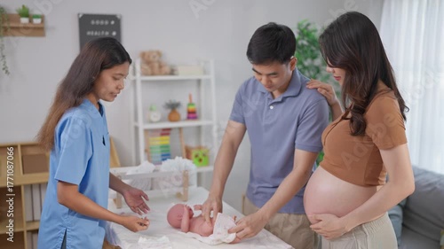 Pregnant woman and husband learn how to wrap a baby at maternal center. 