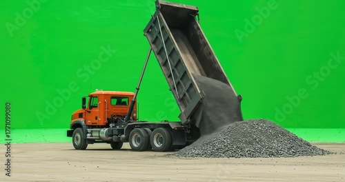 Dump truck unloading gravel against a green screen background.