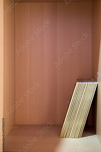 Single Book Leaning in Empty Wooden Shelf
