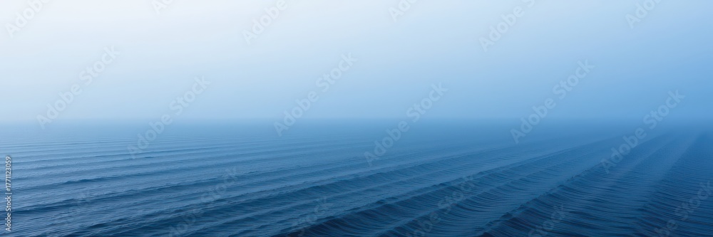 Fototapeta premium Misty fog hovers over a tranquil, deep blue ocean expanse, outdoors, blue