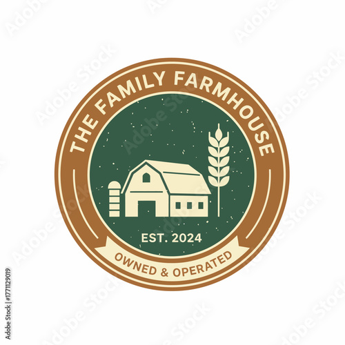 A circular emblem showcasing a barn, wheat, and text, with a ribbon element below