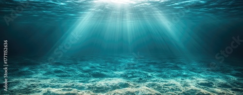 Underwater sunlight beams over sandy seabed