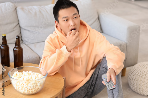 Young Asian man with beer, ...