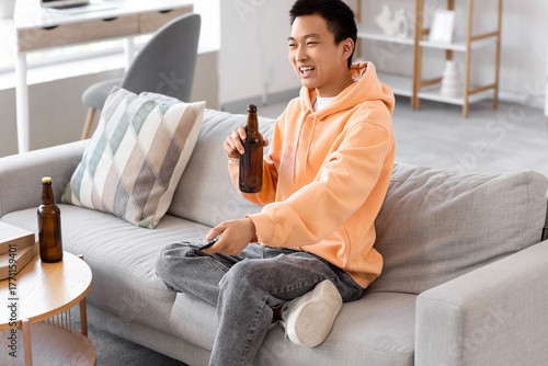 Young Asian man with beer a...