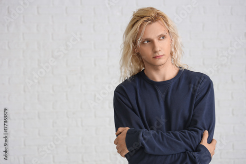 Sad young man on white bric...