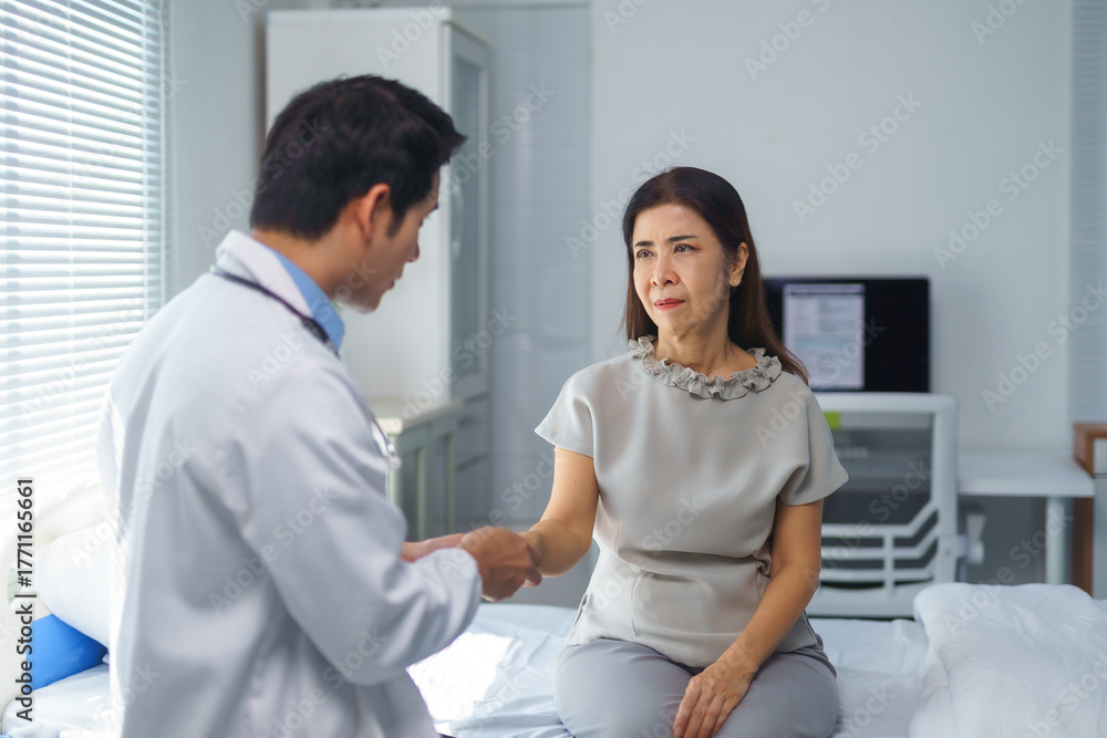 Fototapeta premium Young doctor holding a senior patient's hand, offering comfort and support during an emotional medical consultation