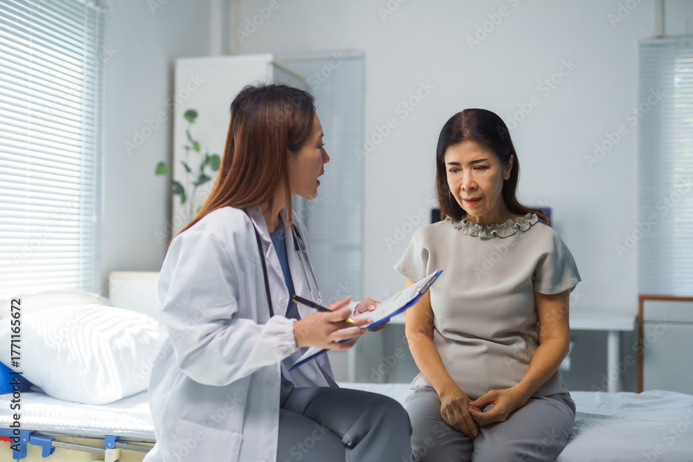 Obraz premium Doctor engaging in a serious discussion with a sad senior Asian woman patient about her medical results in a clinic