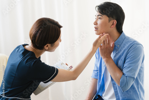 ひげ脱毛する若い男性をカウンセリングをするセラピスト