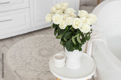 Vase with white roses on ta...