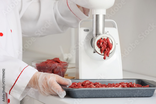 Chef grinding fresh raw mea...